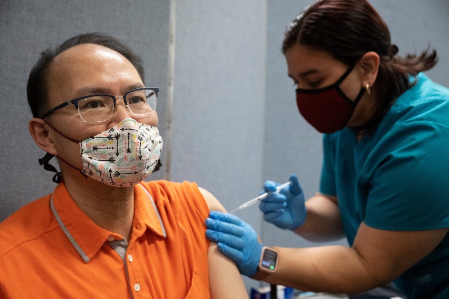 Man receives vaccination at Chinatown site