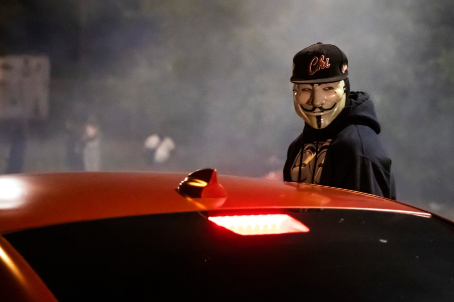masked man near red car