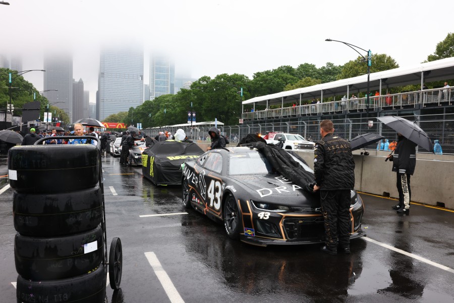 Race cars are uncovered as the NASCAR Grant Park 220 race prepares to begin Sunday in Chicago.