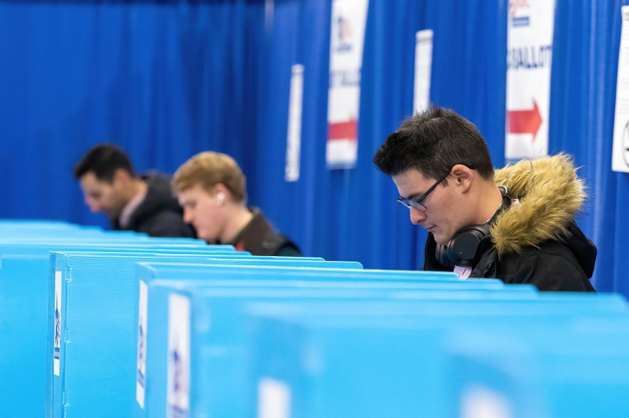 A group of people stand at their voting partitions and vote on the final day of early voting for the Chicago mayoral runoff election at the downtown voting super site, Monday, April 3, 2023.