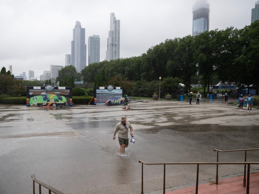 A person walks through a large puddle south of Buckingham Fountain at Sunday's NASCAR Chicago Street Race.