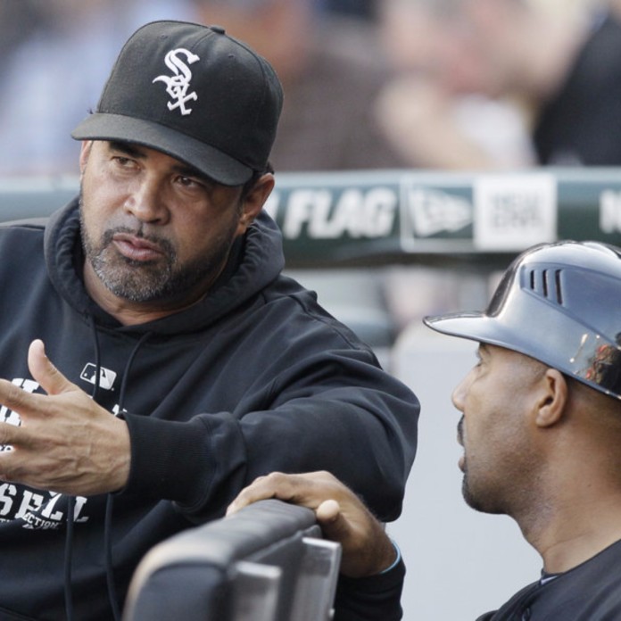 Chicago White Sox first base coach Harold Baines points to the