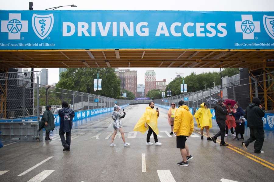 People take photos and videos as they cross the track at East Balbo Drive at Sunday's NASCAR Chicago Street Race.