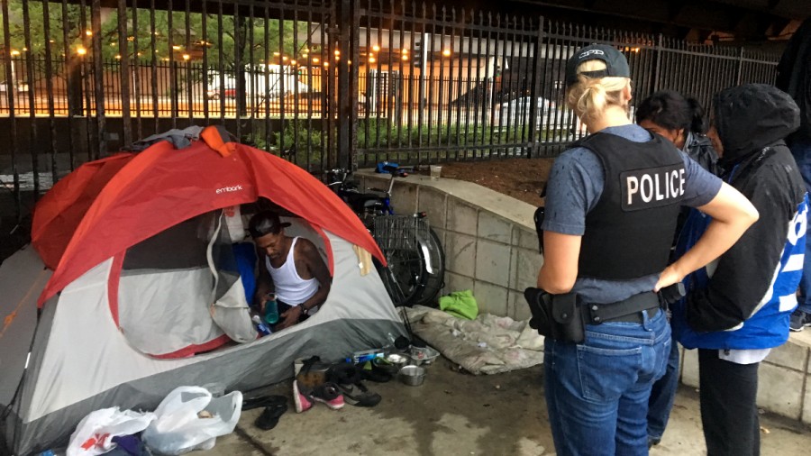 Two Chicago police officers arrived with representatives from the Department of Family and Social Services and Streets and Sanitation Workers to take Smith and Moore’s tent on a rainy day in late July. The officers told WBEZ that tents are not allowed in the central business district.